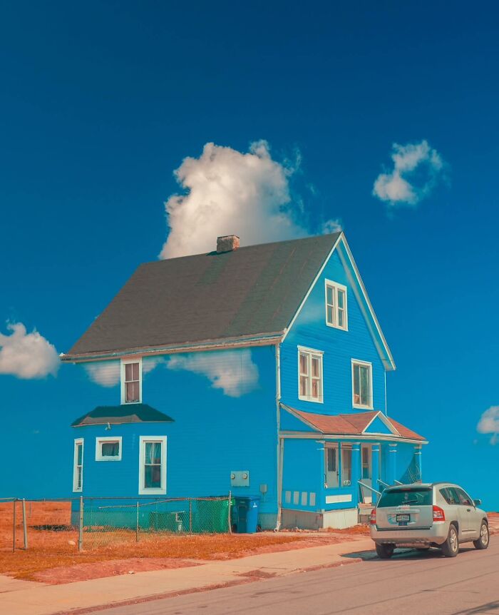 Blue house edited to blend with clouds and sky, showcasing creative photo edits that make you question reality.