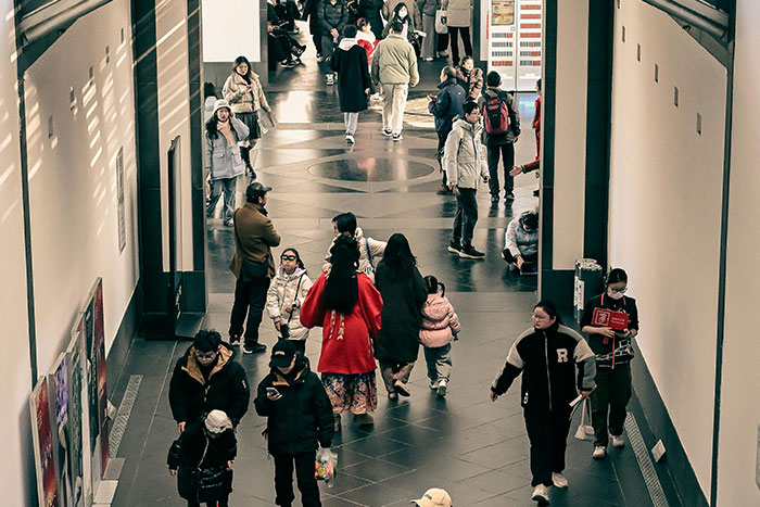 Crowded indoor space with people walking and talking, capturing a moment of uneasy gut feeling in a busy environment.