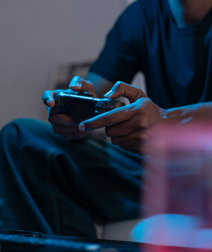 Person holding a game controller indoors, illustrating themes of friendship lost and reasons behind ending long-term friendships.