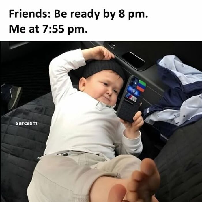 Child lying down and looking at phone in relaxed pose, illustrating hilarious meme about last-minute readiness.