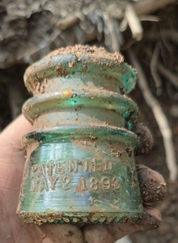 Old glass insulator covered in dirt, one of the strange things found in homes with hidden or forgotten pasts.