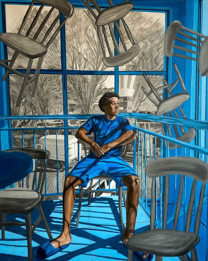 Young man in blue sitting on a chair amid floating chairs, showcasing use of colours and space in the artist's painting.