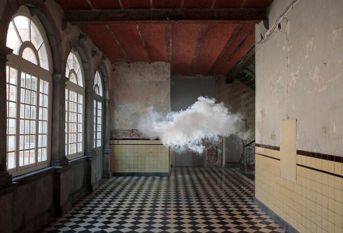 Realistic indoor cloud created using a combination of smoke and water vapor in an empty room with checkered floor.