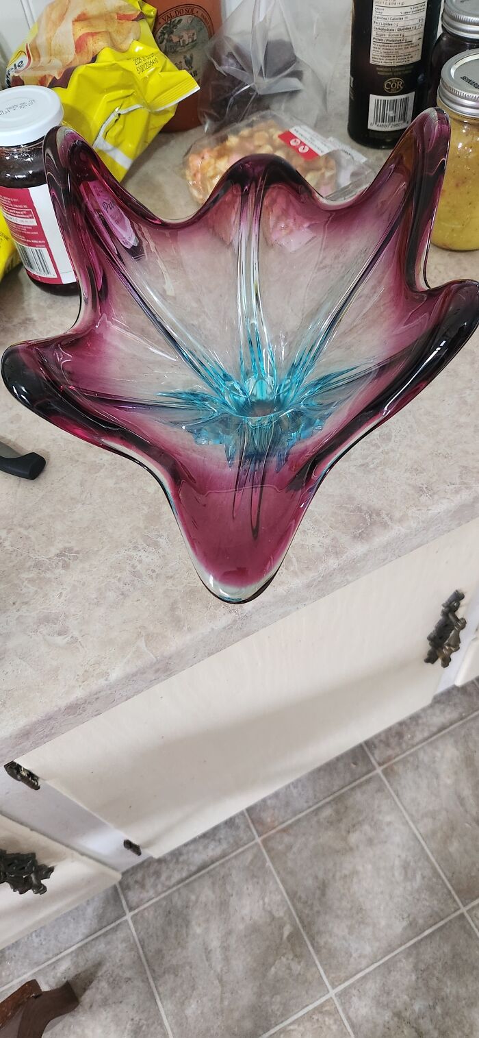 Colorful thrifted glass bowl with purple and blue hues on a kitchen countertop, showcasing weird and wonderful home decor.