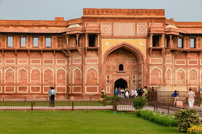 Historic red sandstone building with tourists visiting one of the hidden UNESCO gems showcasing unique architecture.