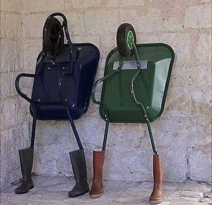 Carretillas con botas en lugar de ruedas, imagen maldita y surrealista que parece cobrar vida frente a una pared de piedra.