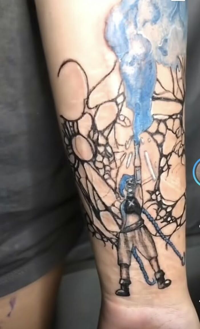 Tattoo of a person painting blue with abstract black line work, showcasing a cool inked design with a permanent mistake.