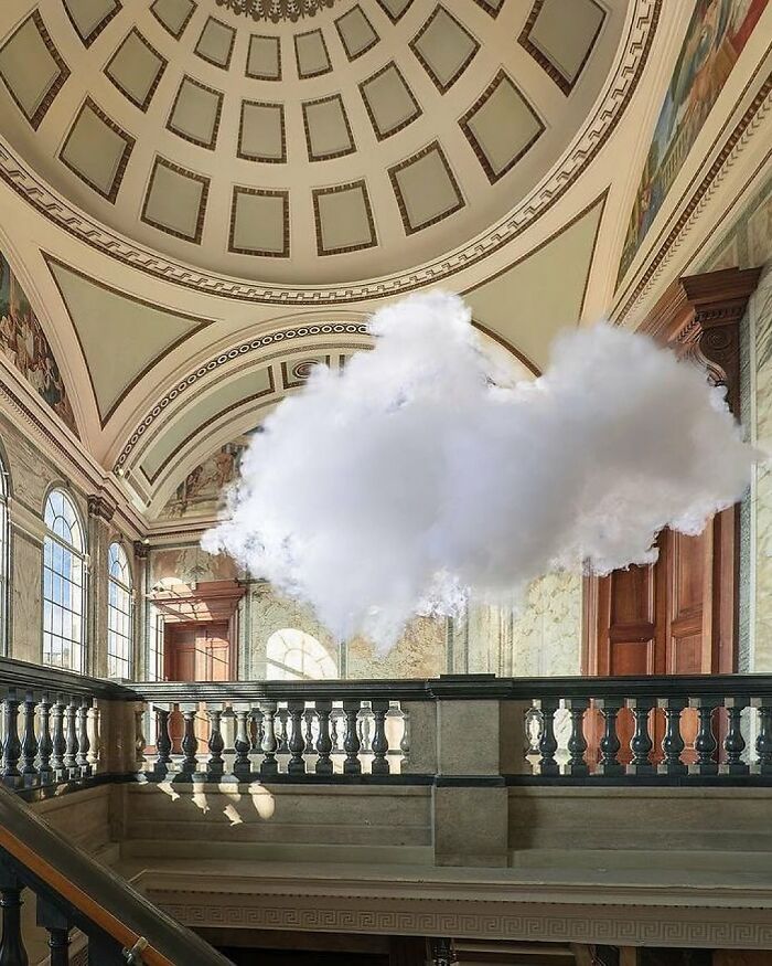 Realistic cloud made of smoke and water vapor floats inside an ornate indoor space with a dome ceiling and large windows.