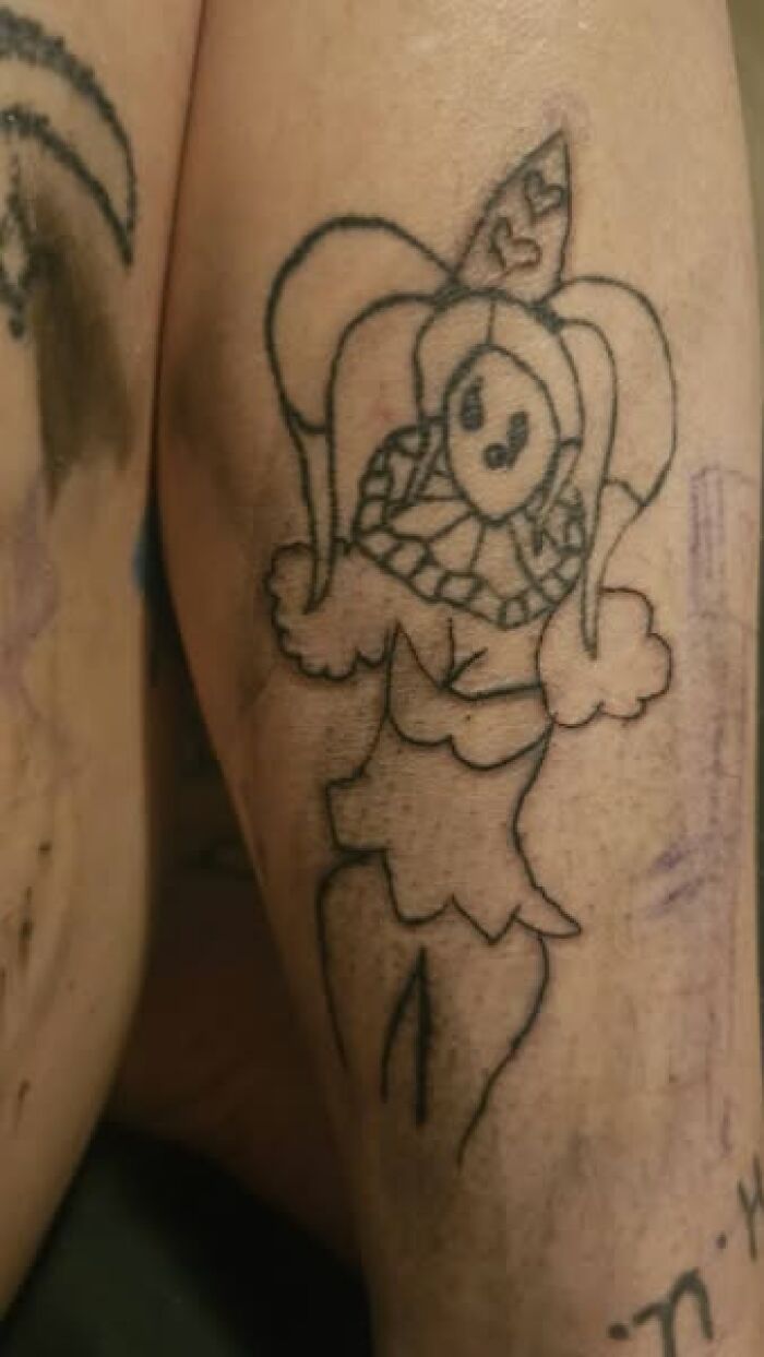 Poorly executed tattoo of a cartoonish jester on forearm, an example of a permanent mistake in inked tattoos.