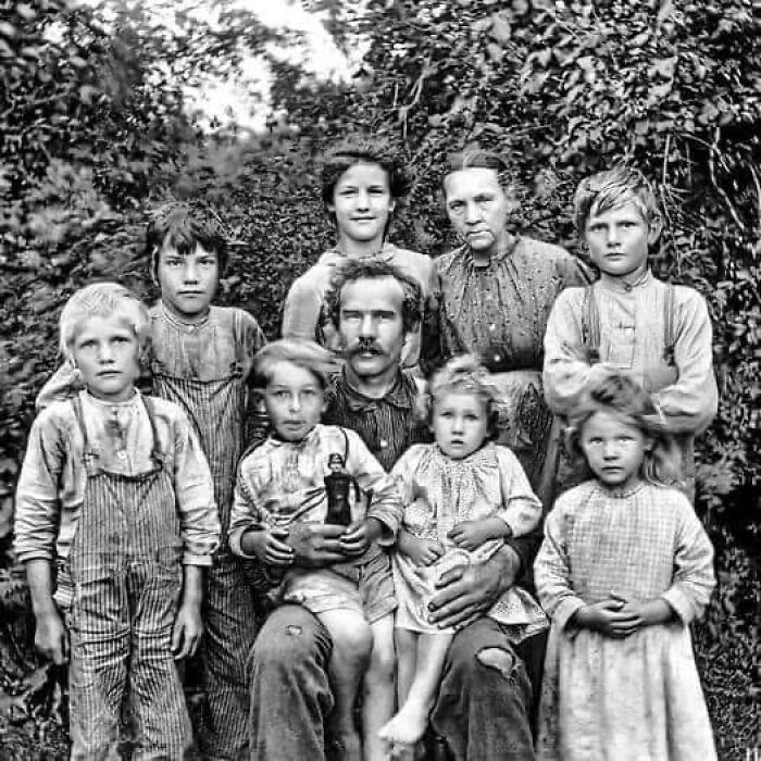 Antique historical photograph of a family group outdoors, showing clothing and expressions from a past era.