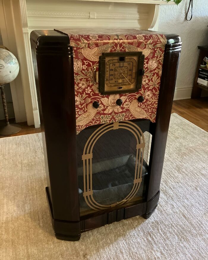 Vintage TV restored with decorative fabric and glass front, transformed into a cozy cat bed for nostalgic nooks.