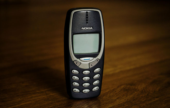 Old Nokia mobile phone standing on a wooden surface representing 14 people recalling times strangers unsuccessfully tried to mug them.