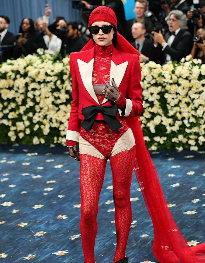Model wearing a bold red lace outfit and blazer, one of the biggest fashion fails from the Met Gala 2025.