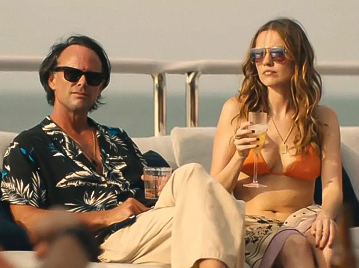 Aimee Lou Wood and Walton Goggins sitting outdoors, relaxing and enjoying drinks on a sunny day. Aimee Lou Wood and Walton Goggins sitting outdoors, relaxing and enjoying drinks on a sunny day.