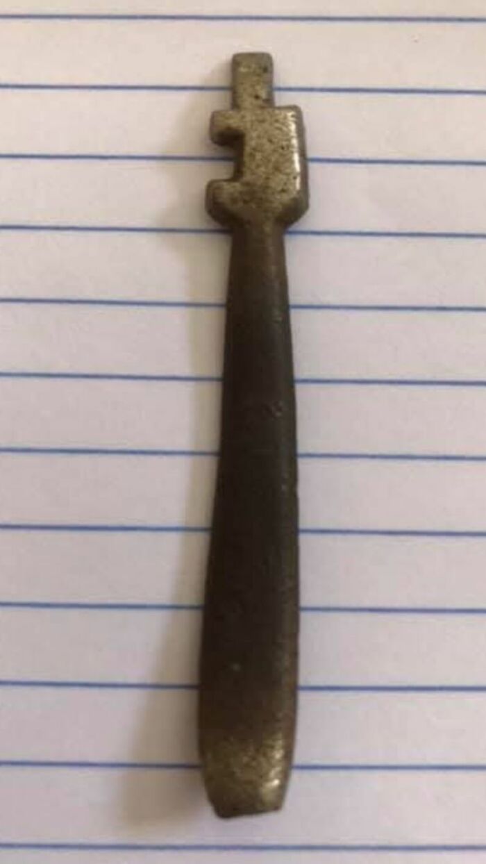 Old rusty key with unusual shape found among strange things in homes with hidden and forgotten pasts.