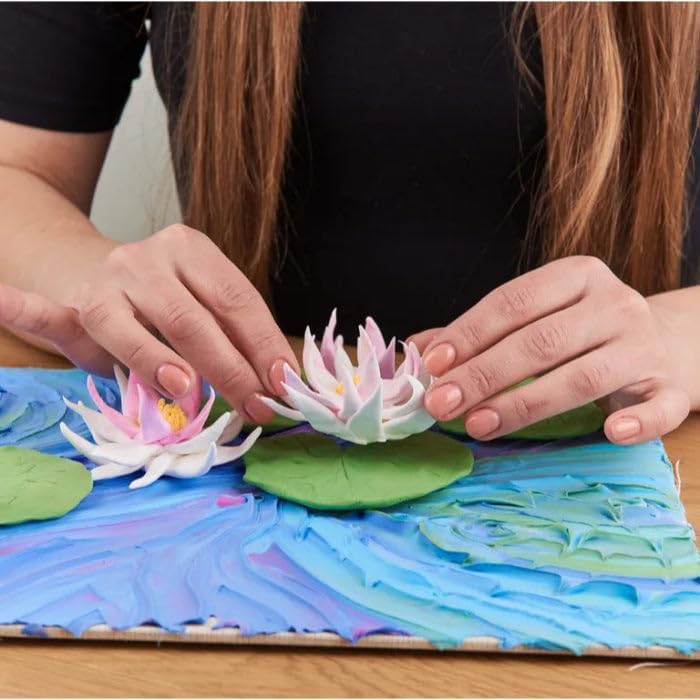 Hands shaping clay water lilies on a colorful surface, showcasing hobbies where trying your best is the key skill.
