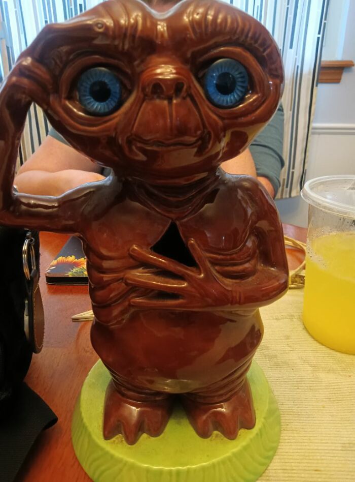 Ceramic figurine of a creature with large blue eyes, a textured body, and quirky pose, a weird and wonderful thrifted find.