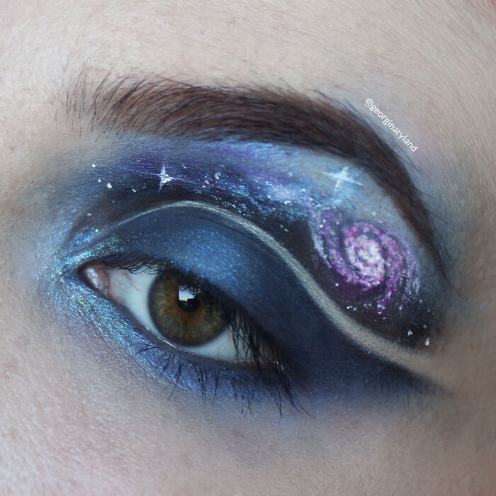 Close-up of an eye with galaxy-inspired makeup featuring blue and purple shades, highlighting incredible makeup looks by talented artists.
