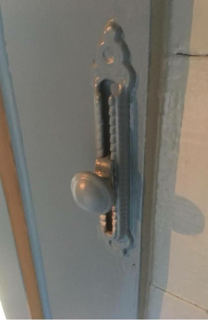 Close-up of a vintage door k**b and ornate latch, one of the strange things found in homes with hidden pasts.