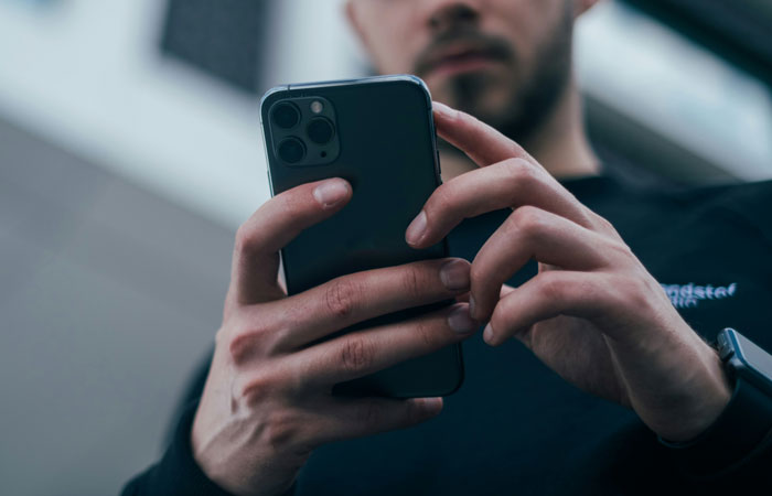 Man holding smartphone with focused expression illustrating stranger mugging attempts recalled by people.