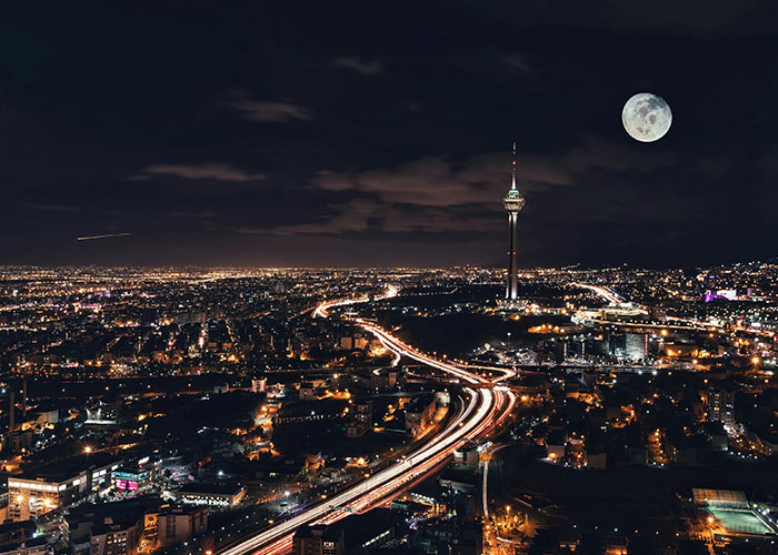 Night cityscape with illuminated roads and a full moon, illustrating the best and worst things about living in home countries.