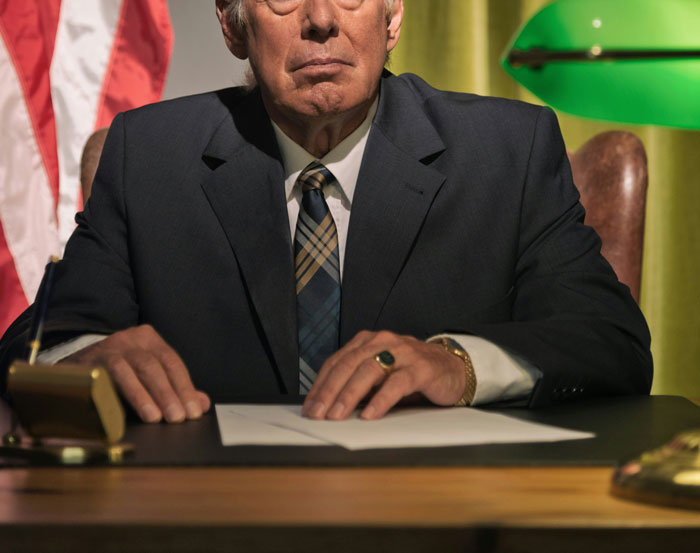 Older man in a suit sitting at a desk with papers, symbolizing the end of a long friendship of 10 plus years shared reasons.