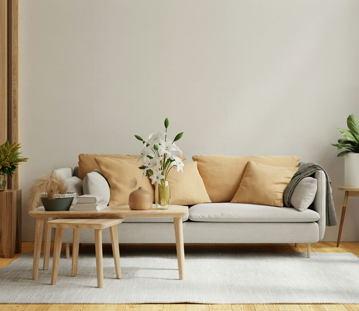 Living room with beige sofa, pillows, and wooden tables, a calm space for reflecting on weird parenting rules.