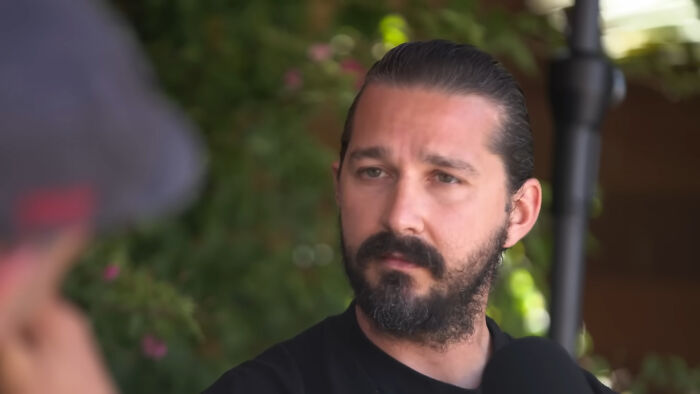 Actor with a beard and tied-back hair speaking in an interview about miscast actors in movies.