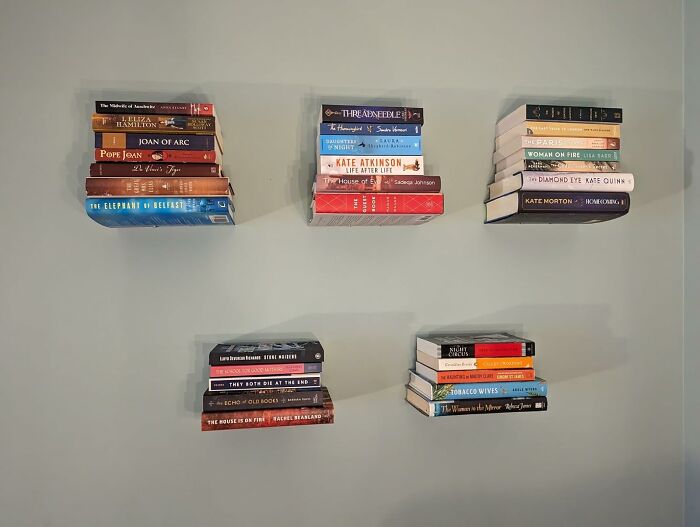 Floating bookshelves installed on a gray wall as a weekend home upgrade for fast and stylish organization.