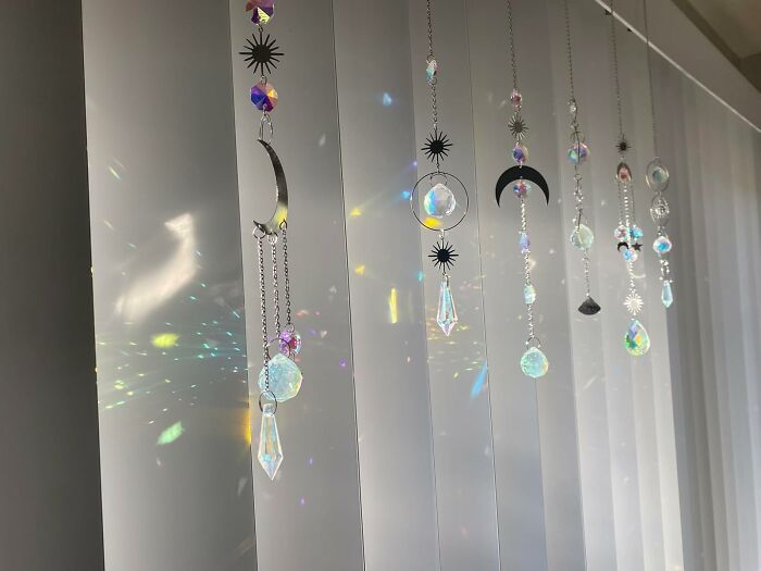 Hanging crystal suncatchers with moon and star designs creating light reflections, popular affordable finds on Amazon.