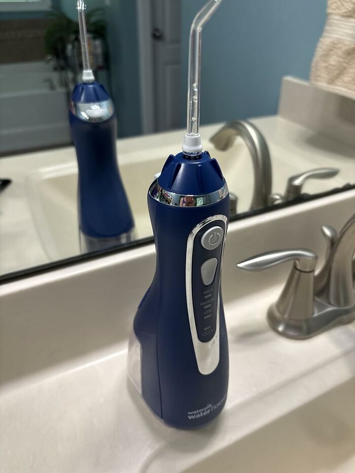 Blue Waterpik water flosser on bathroom sink, featured in Amazon Memorial Day sale with top deals to grab quickly.