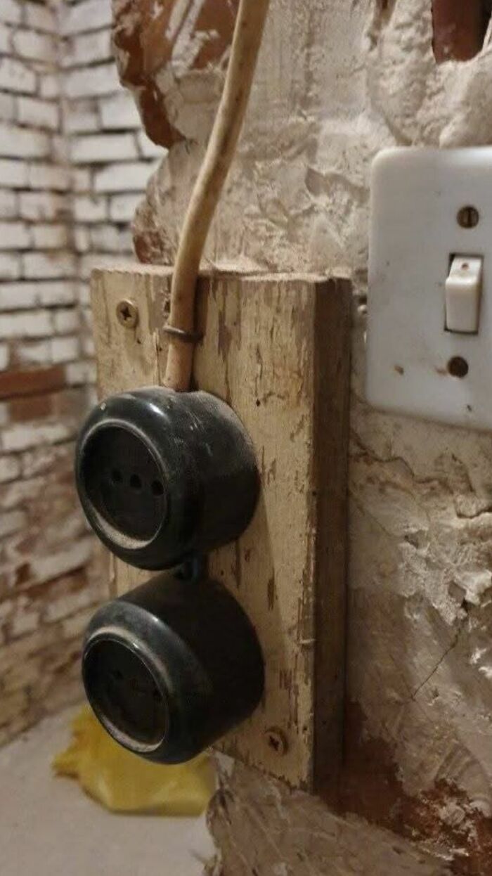 Old vintage electrical outlets mounted on wood in a home with hidden and forgotten haunted pasts.