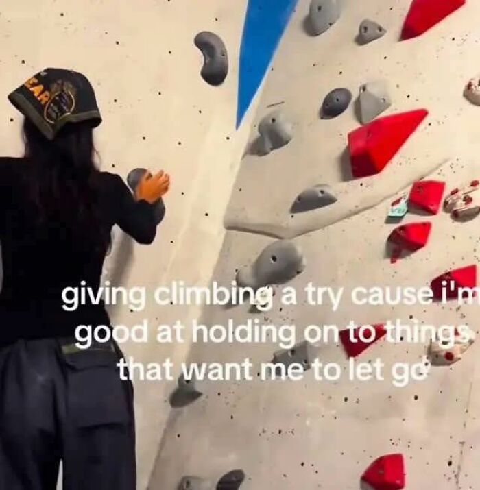 Person attempting indoor rock climbing with caption about holding on to things, fitting funny pics and mental breakdowns theme.
