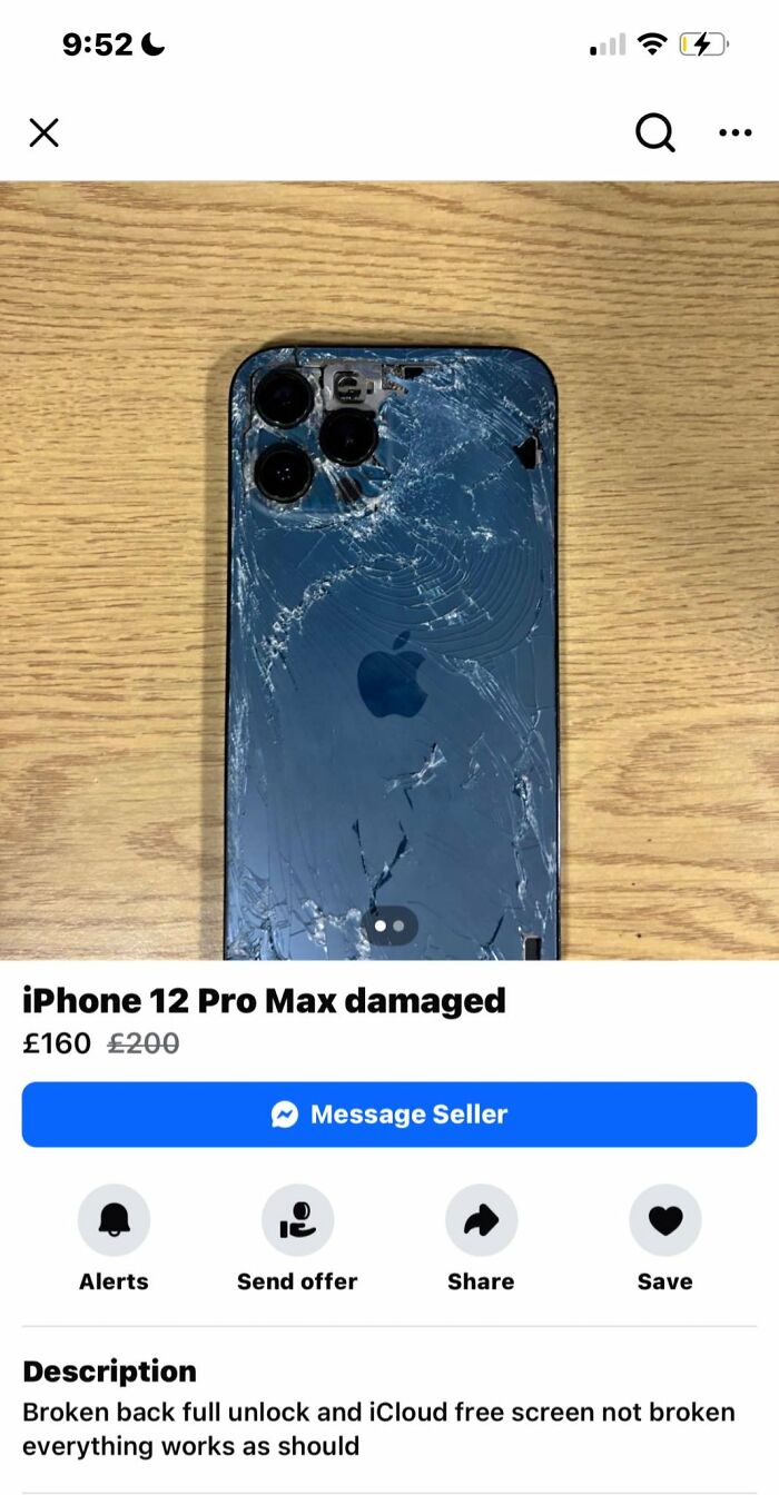 Damaged iPhone 12 Pro Max with shattered back glass listed for sale on Facebook Marketplace on a wooden surface.