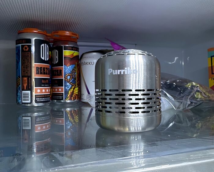 Metal air purifier in fridge with drinks and snacks, one of the items that fix everyday annoyances creatively.