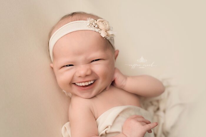 Smiling baby with headband edited with hilarious Photoshop skills, showcasing creative and funny image manipulation.