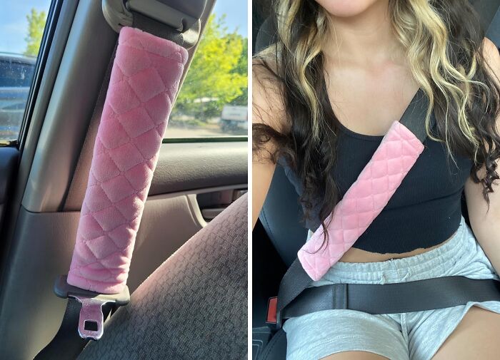 Soft pink quilted seatbelt cover installed on car seatbelt and worn by a person in casual clothes inside a vehicle.