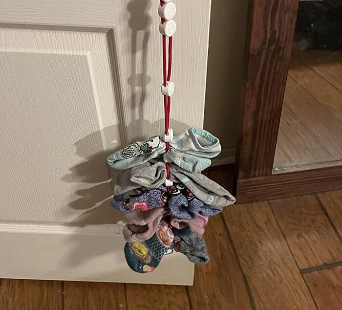 Hanging organizer with various socks clipped, demonstrating a simple way to ditch the slob life and stay organized.