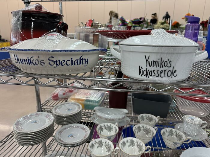 Thrifted finds including unique labeled casserole dishes and vintage china displayed on metal shelves.