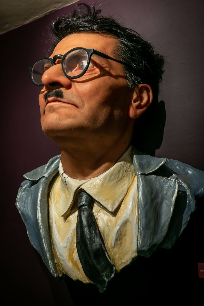 Hyper-realistic sculpture by Ruben Orozco Loza showing a man with glasses, mustache, and a suit in detailed craftsmanship.