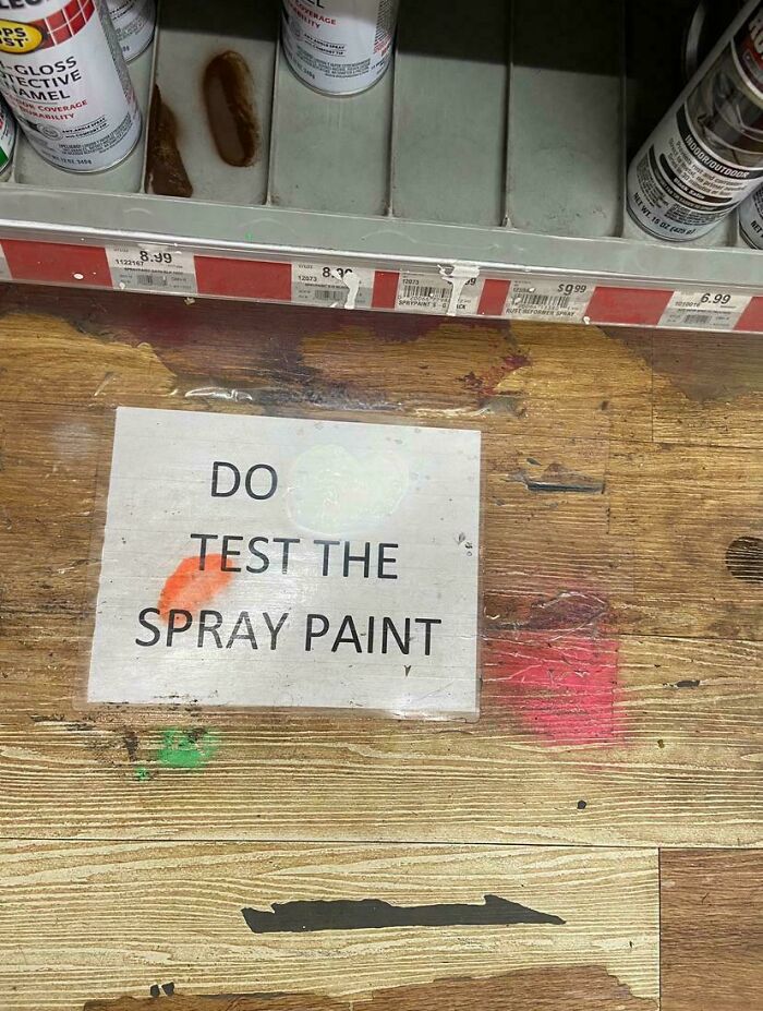 Sign on a wooden shelf in a store encouraging customers to test the spray paint, showing wholesome vandalism in urban streets.