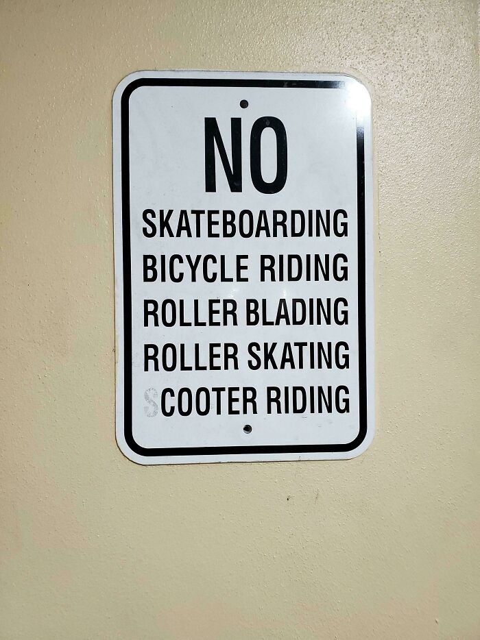 No skateboarding, bicycle riding, rollerblading, roller skating, or scooter riding street sign in a public area.