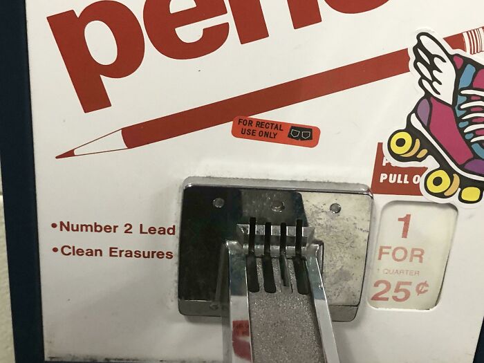 Pencil vending machine humorously altered with a sticker, showcasing wholesome vandalism improving street art.