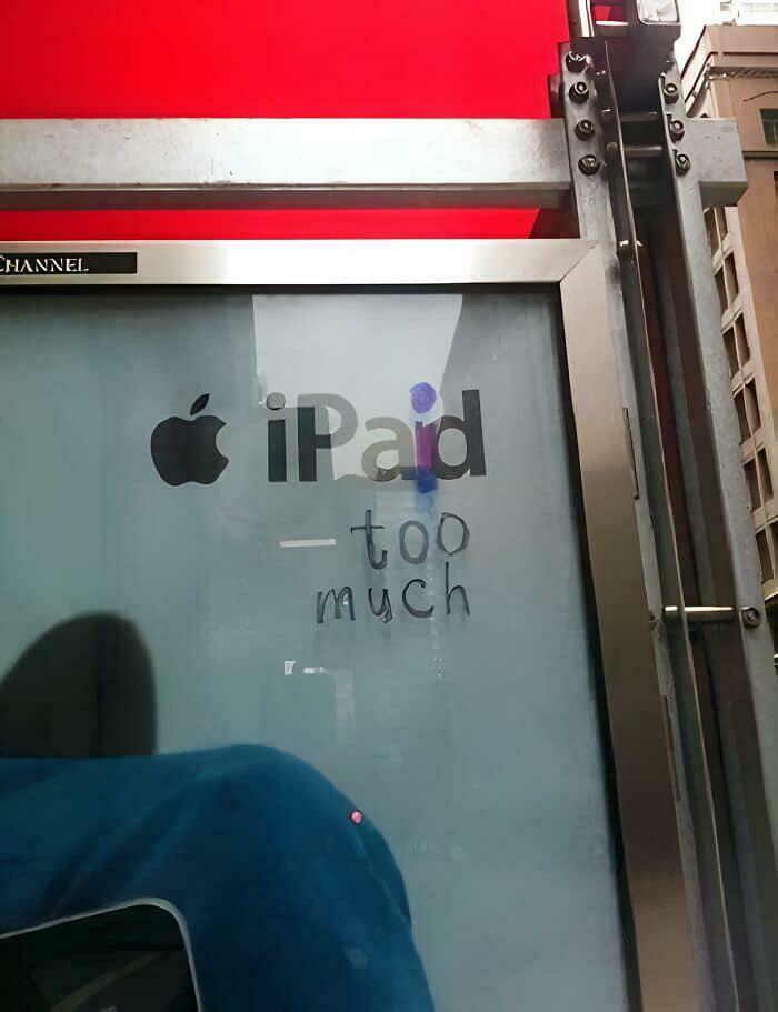 Street art vandalism humorously alters Apple iPad ad, showcasing wholesome vandals making streets look and feel better.