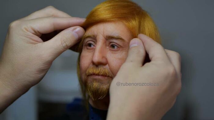 Hands adjusting hair on a hyper-realistic sculpture by Ruben Orozco Loza showcasing breathtaking realism in art.