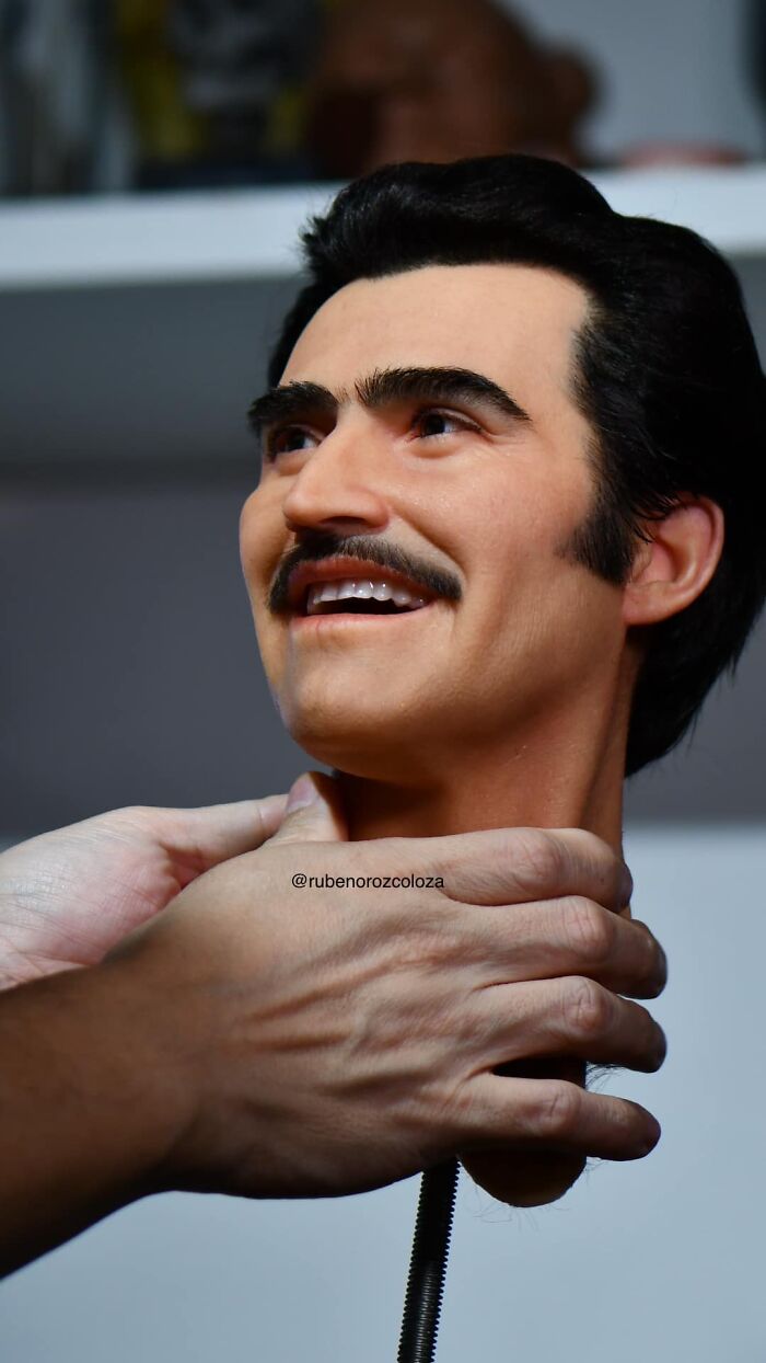 Hyper-realistic sculpture head held by hands showcasing Ruben Orozco Loza’s breathtaking realism in art.