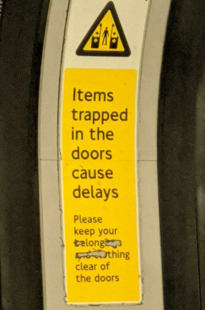 Warning sign on public transport about items trapped in doors causing delays, promoting wholesome street improvements by creative vandals.