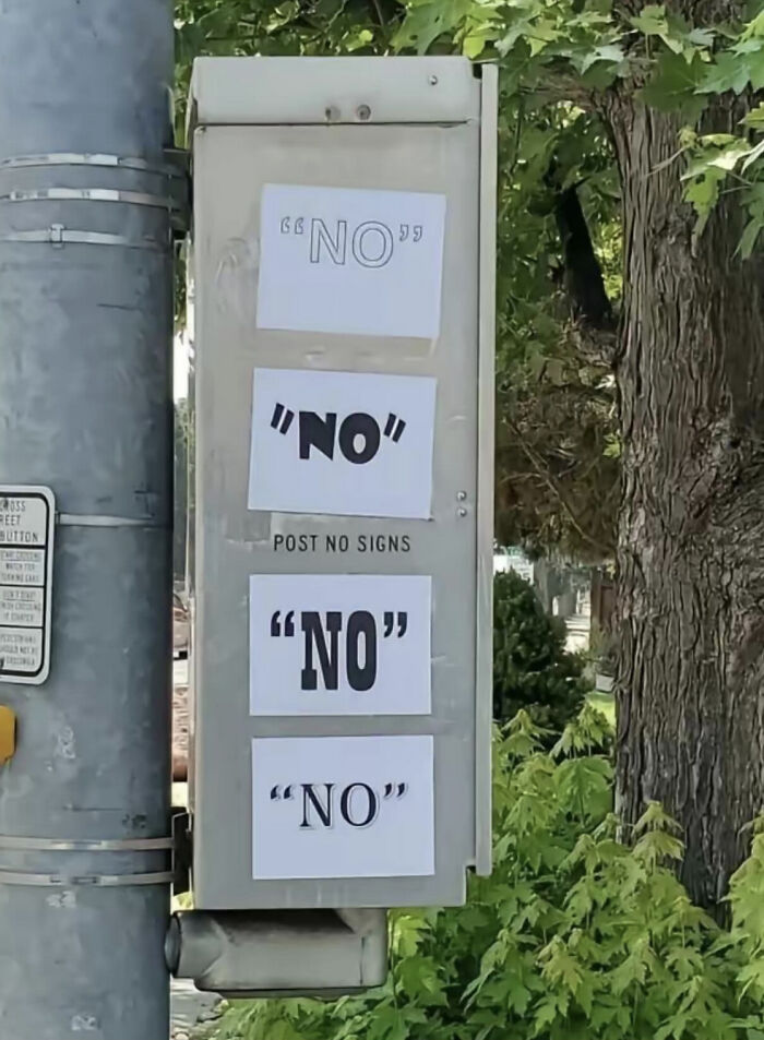 Street utility box humorously covered with multiple "NO" signs, showcasing wholesome vandalism improving urban spaces.