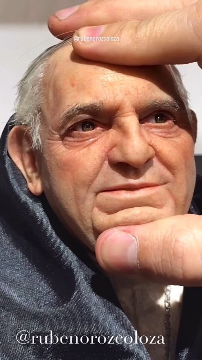 Hyper-realistic sculpture by Ruben Orozco Loza showing detailed elderly man's face with lifelike skin texture and expression.