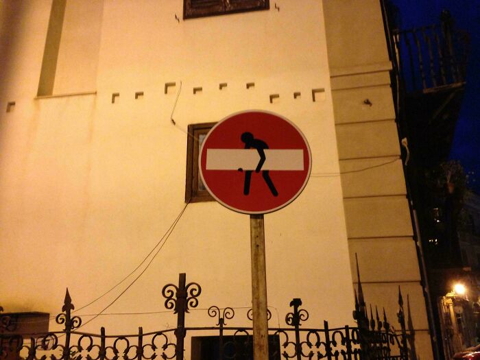 Street sign creatively altered by wholesome vandals, enhancing urban art and making streets look and feel better at night.